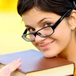 mujer estudiante de gafas sonriendo con libro en la mano